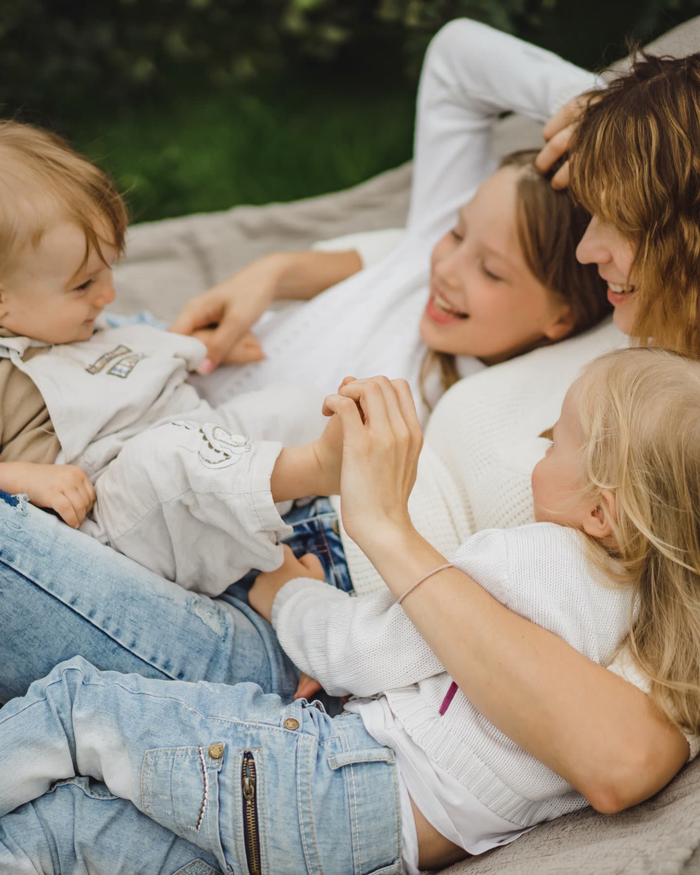 A caregiver laughing with three young children